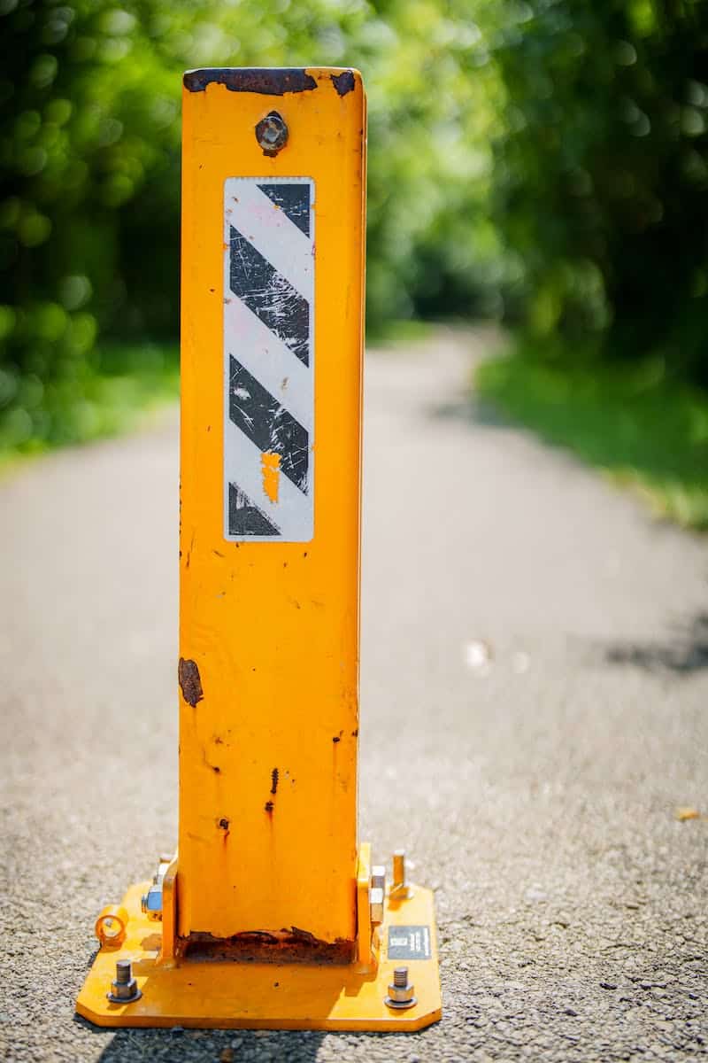 Yellow Traffic Guard Bollard Standing on Asphalt Footpath